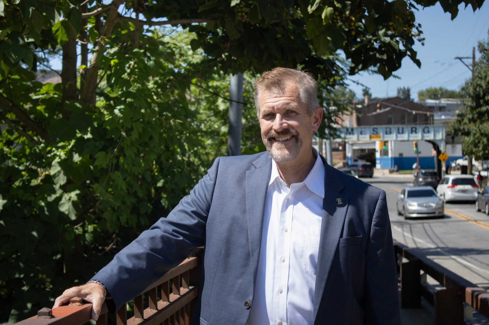 Bill Griffin standing on a footbridge in Holmesburg with the neighborhood behind him
